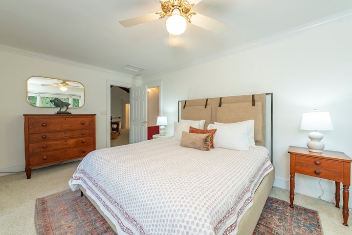 Second-floor ensuite bedroom with a king-size bed, TV, closet, walk-in shower, and workspace