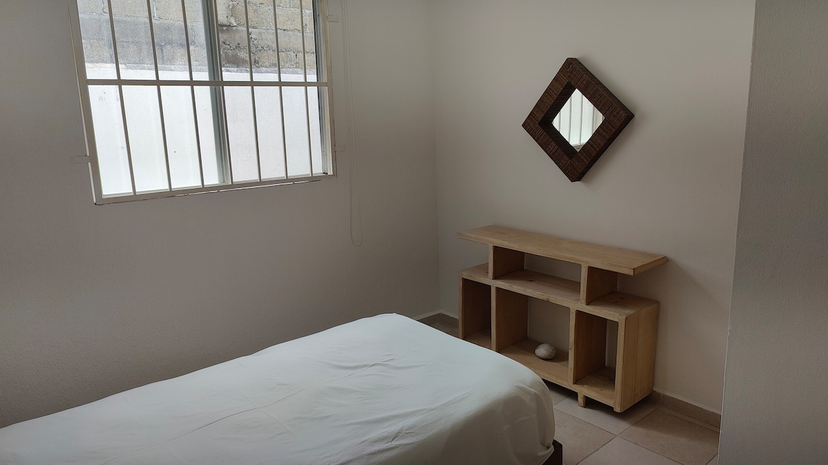 سرير مفرد مع طاولة تسريحة صغيرة تجعل هذه المساحة مريحة 