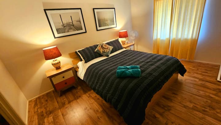 Krevat dopio "queen" i rehatshëm me garderobë në dhomën e parë të gjumit.