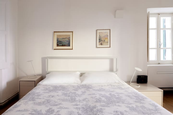 Cama de casal grande, colchão confortável, ar-condicionado, armário, duas janelas.