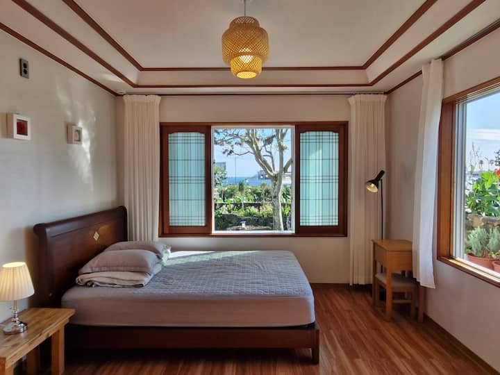 **Habitación 1**

Las ventanas dan al sur y al oeste, por lo que puedes sentir el sol cálido y la brisa fresca. Puedes ver el jardín y el mar. 

Uso: cama (queen), chimenea.