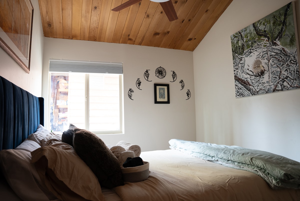 Cama tamaño queen con funda nórdica y edredón de plumas, almohadas de espuma viscoelástica y persianas opacas para una noche de sueño reparador. Obras de arte locales con Jackie, la famosa águila calva de la zona.