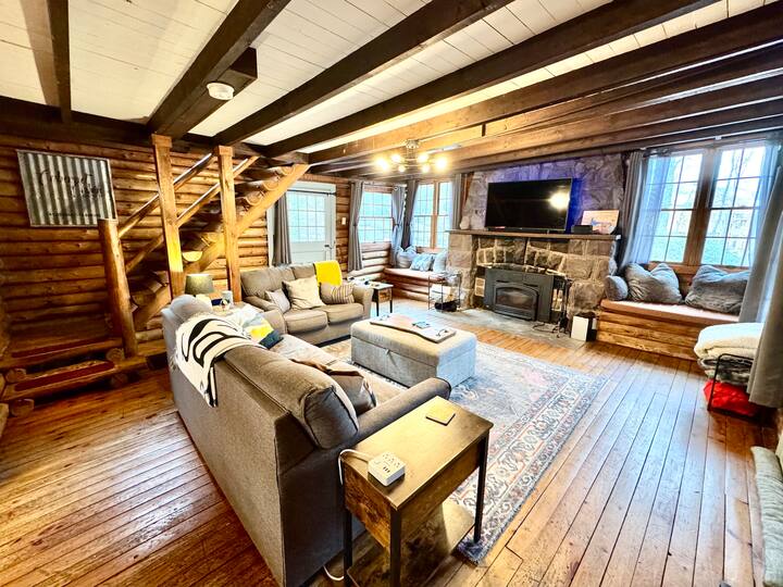 Მისაღები ოთახი 56-დუიმიანი ტელევიზორითა და შეშის ბუხრით.