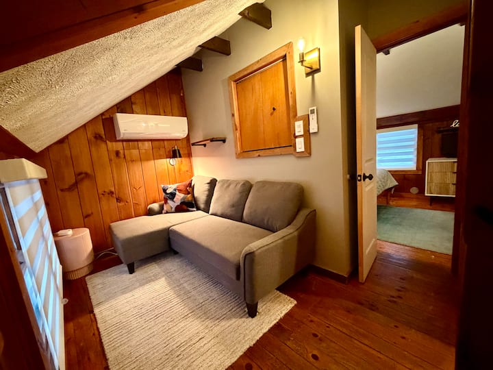 Cozy loft lounge with AC, wood beams, and a comfy nook by the bedroom.
