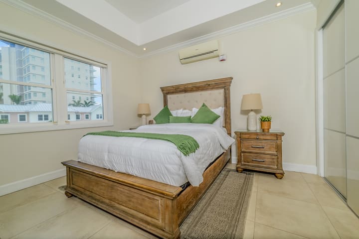 Chambre secondaire confortable et accueillante, bénéficiant d'une lumière naturelle douce, avec salle de bain attenante et TV Smart.