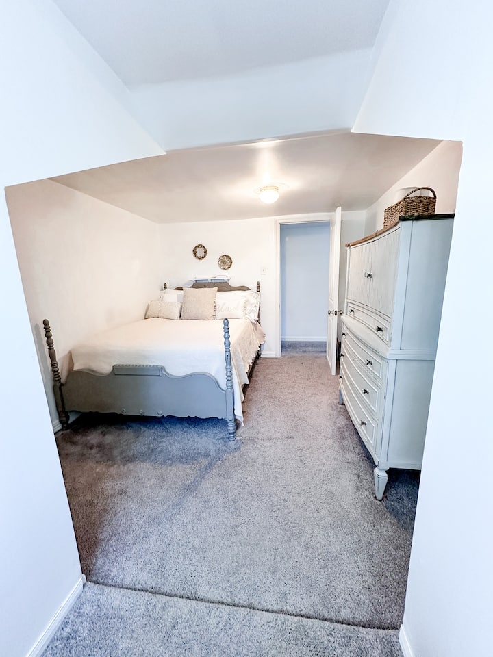 This room at the end of the hall by the bathroom has a dresser and a reading nook under the dormer window.