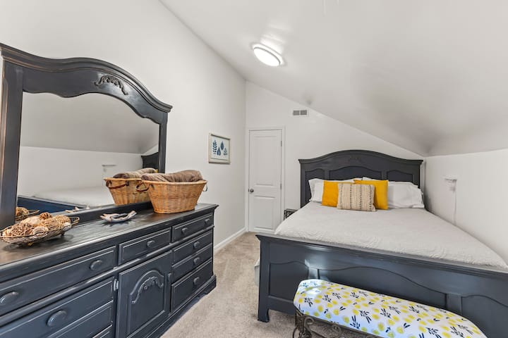 This bedroom is home to the queen bed, a closet and large dresser.