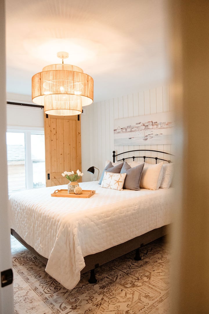 Oddýchnite si v svetlej a štýlovej hlavnej spálni s moderným pobrežným štýlom, pohodlnou manželskou posteľou, jemnými textúrami a upokojujúcim dekorom, čím si vytvoríte dokonalé súkromné útočisko pre pokojný pobyt.