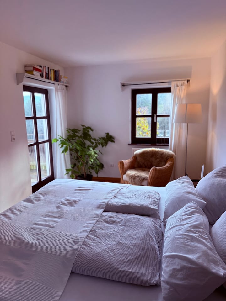 Un acogedor sillón en el dormitorio con vistas al balcón.