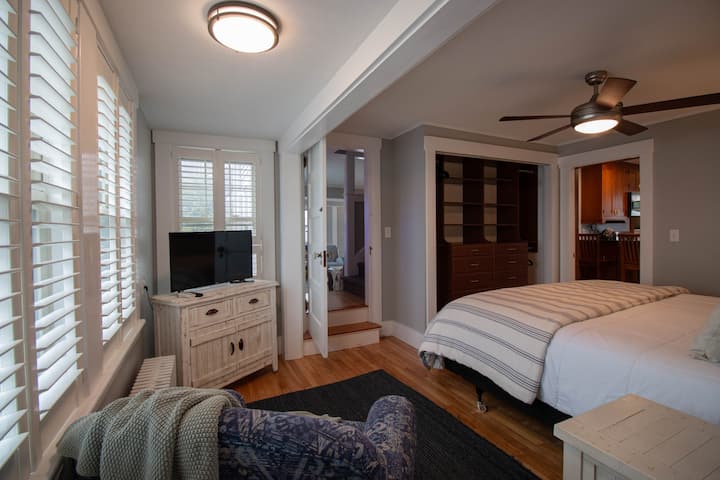 First-floor primary bedroom with a dedicated closet space and smart TV.