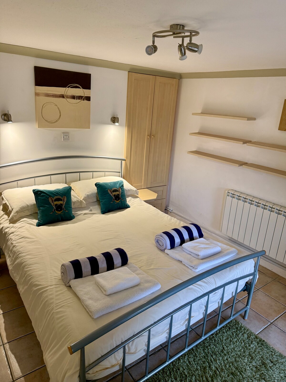 Dhomë gjumi me madhësi king në katin përdhes të poshtëm me hyrje në verandë