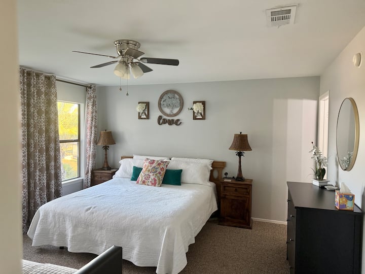 Primaire slaapkamer met eigen badkamer en uitzicht op het strand, het meer en het zwembad