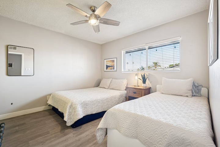 El dormitorio de invitados 2 cuenta con una cama tamaño queen, una cama doble y un escritorio con una silla.