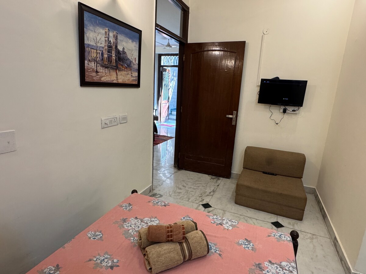 Винтиџ брачен кревет од тиково дрво со странична масичка. Паметен телевизор монтиран на ѕид.