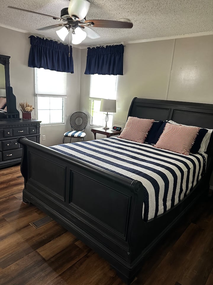 De master heeft een queensize bed, dressoir, stoel, plafondventilator en een aangrenzende badkamer die vrij mooi is in grootte met een bad en een kleine douche. 