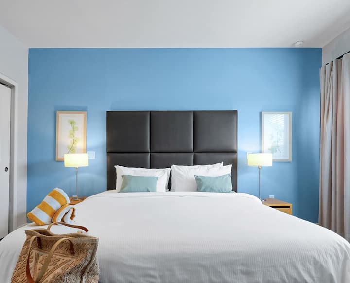 在经历了一天的冒险后，您可以沉浸在主卧套房的舒适加大双人床中。 正如每个假期的回忆都是独一无二的，我们房间的墙壁颜色和床头板可能有所不同，为您的住宿增添一丝个性魅力。