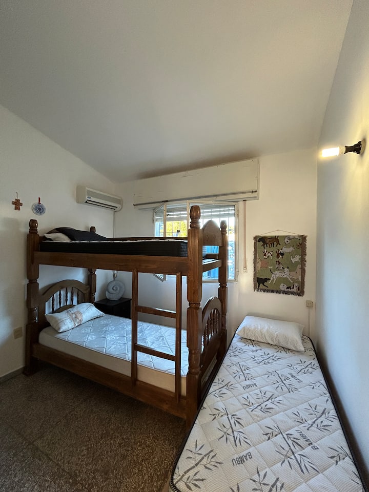 Მეორე ოთახი:
სამი საწოლი 1 საცხოვრებელში (ერთი ერთადგილიანი, ერთი ორსართულიანი). 
ჩაშენებული კარადები. საძინებლის მაგიდა და ლეპტოპი.
3 ბალიში, 2 საბანი, 1 გადასაფარებელი.
• კონდიციონერი
• ფანჯარა ჟალუზებითა და ხის ბოძებით სახლის უკანა მხარეს.