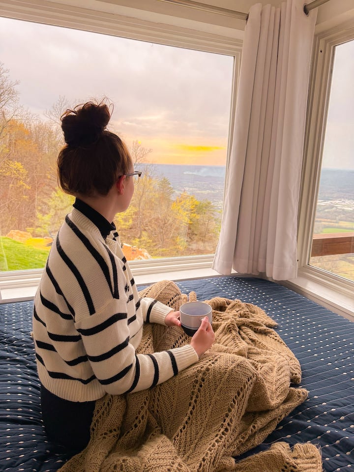 The bedroom windows frame a peaceful panorama of the surrounding landscape.