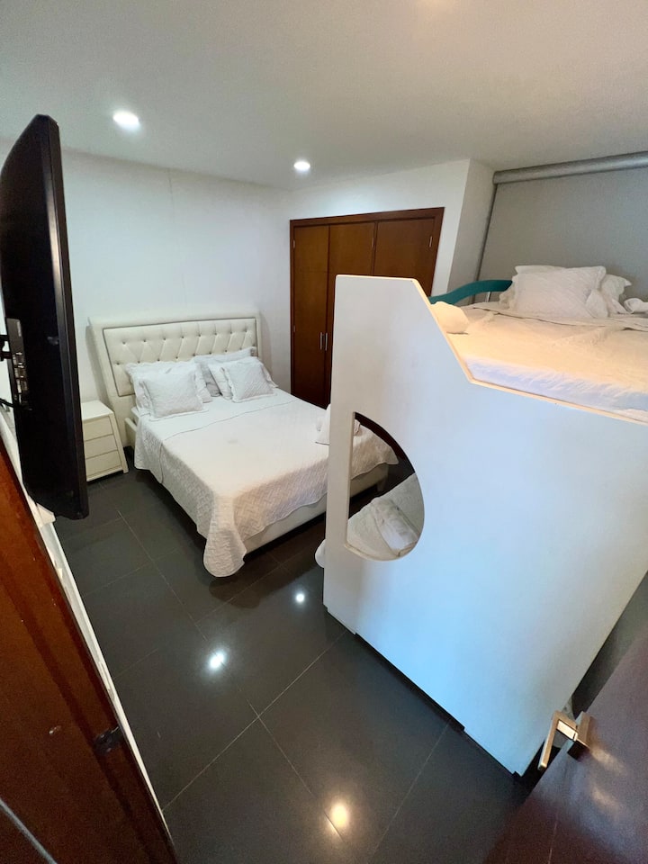 Perfect for families or friends! This flexible guest room features a comfortable full-size bed and a twin bunk bed setup, and a wall-mounted flat screen TV.