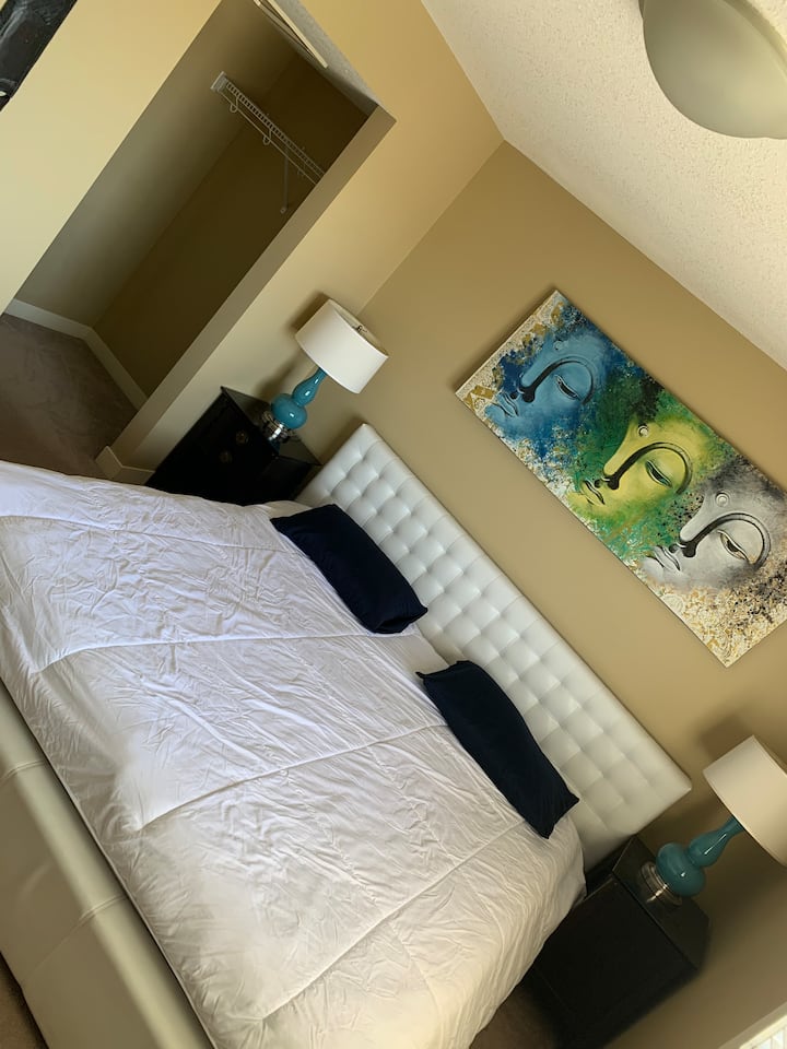 חדר שינה ראשי עם חדר ארונות ודלת גישה לחדר האמבטיה 