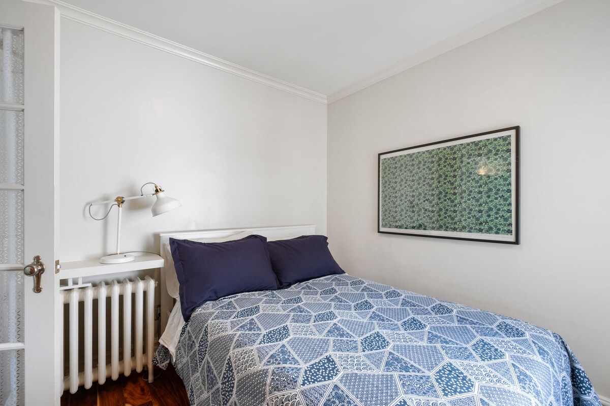 双人床，配备床头柜和阅读灯。