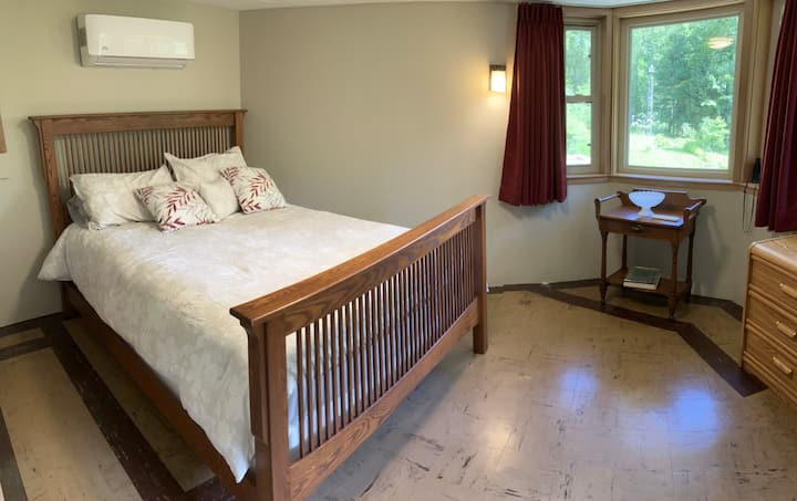 The queen size master room offers an outstanding view of the property, greenhouse, patio and the river below. It includes a full closet, individualized HVAC, dresser, light darkening curtains, & a pack and play. New mattress and luggage rack. 
