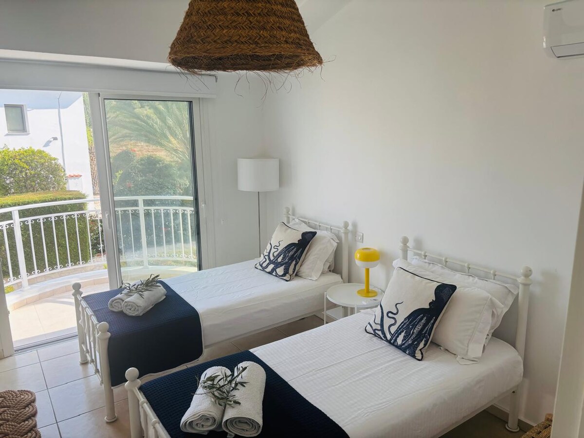 Tercer dormitorio con dos camas individuales, balcón privado y baño propio