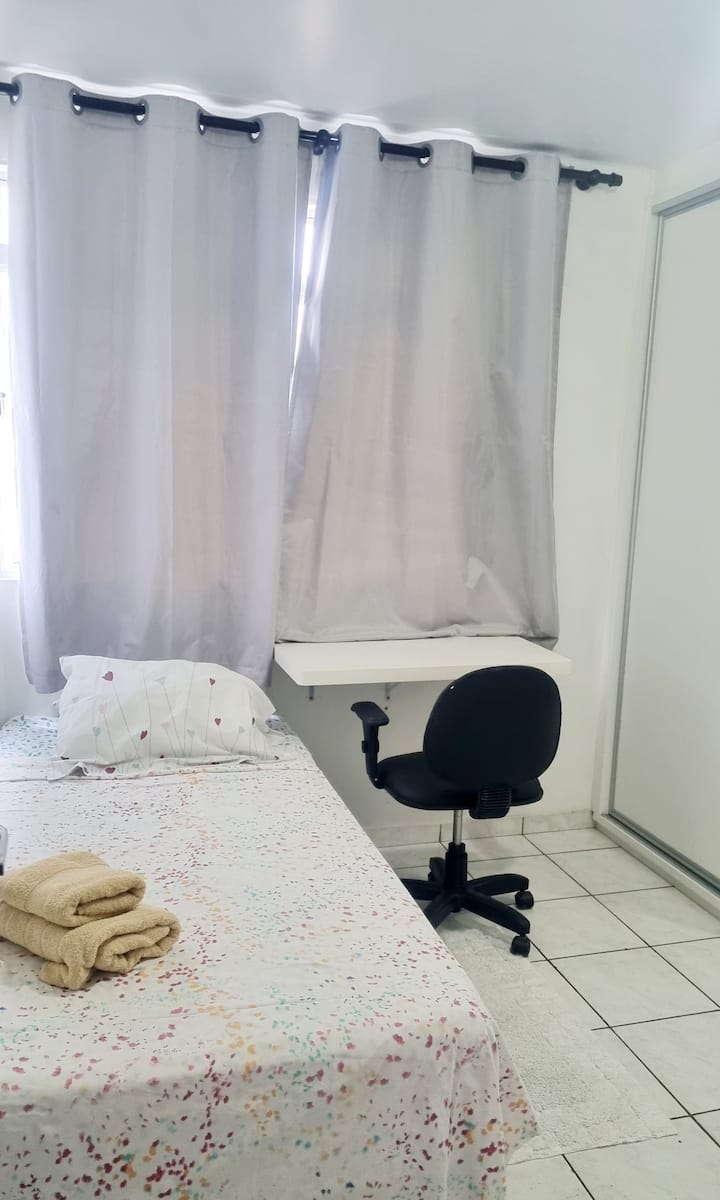 chumba cha kulala kilicho na kitanda cha mtu mmoja, meza ya kujifunza,  kiti, kabati la nguo na feni 