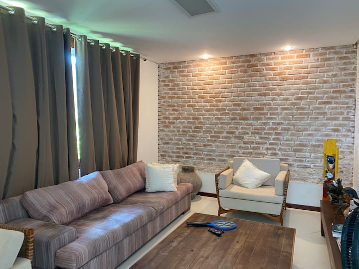 تحتوي غرفة المعيشة على تلفزيون ذكي وأريكة مريحة وكرسيين بذراعين، مما يخلق جوًا مريحًا ومثاليًا للاسترخاء.