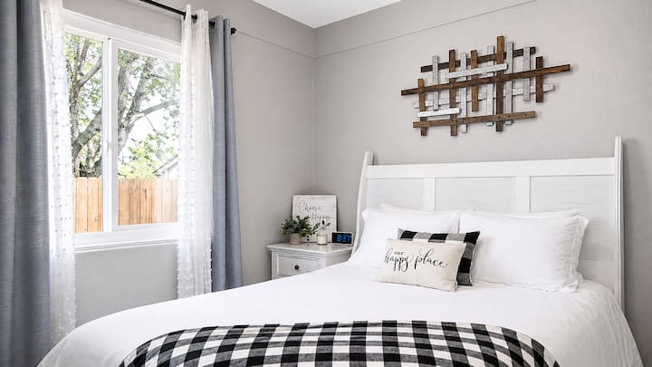 Bright, cozy bedroom with plush bedding, rustic decor, and sunny views