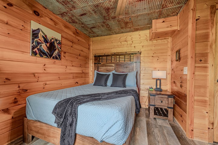 Chambre confortable dans un chalet, avec lit Queen Size, plafond en métal rustique et bois chaleureux