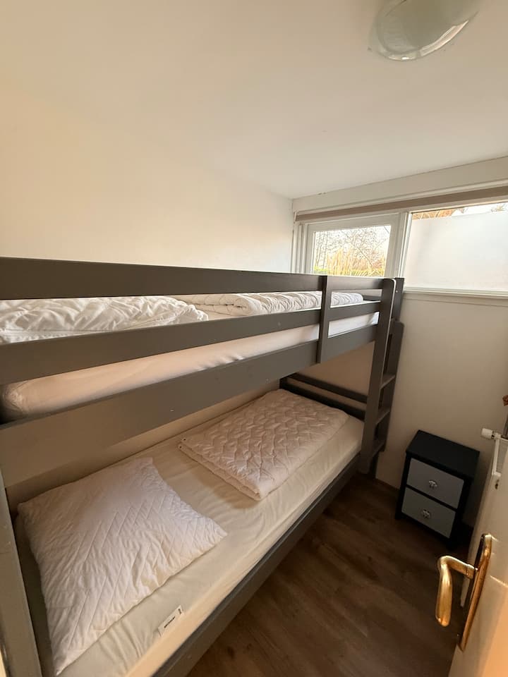 חדר שינה ל-2 אנשים עם מיטת קומותיים ושידת לילה.