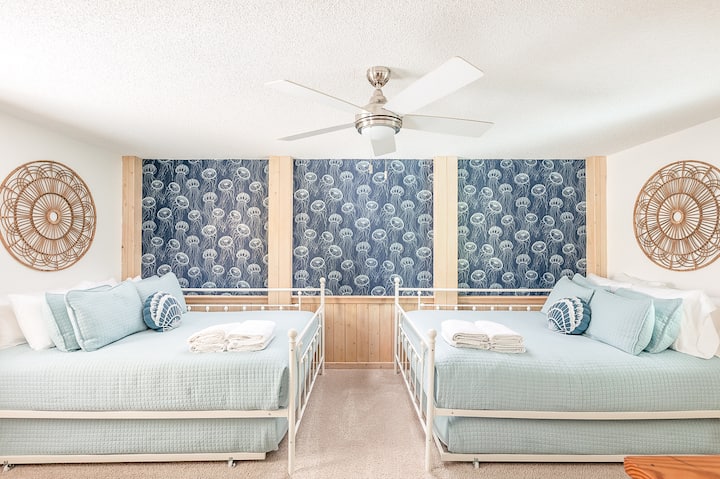 Bedroom 5 (two queens + two double trundles) is on the ground level with a nearby half bath and outdoor shower.