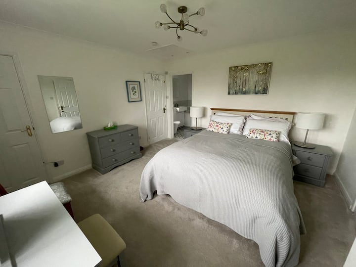 主卧配有一张2米宽双人床、一个内置衣柜、一个梳妆台和一个角落的公用橱柜。