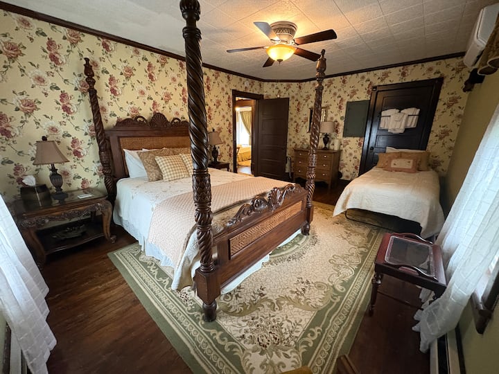 A large bedroom with both a queen and single bed with ceiling fan and mini-split.  Shares the hallway bath with the "red room".