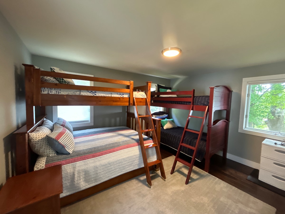 La chambre avec lits superposés a un lit superposé double et un lit superposé double avec un lit gigogne simple en dessous. 