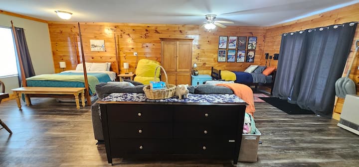 Large first floor bedroom with entertainment area, one queen bed, two twin beds, and a 6 person table. This bedroom is accessible via the mudroom and downstairs bath. It also opens to the back yard patio and grill.