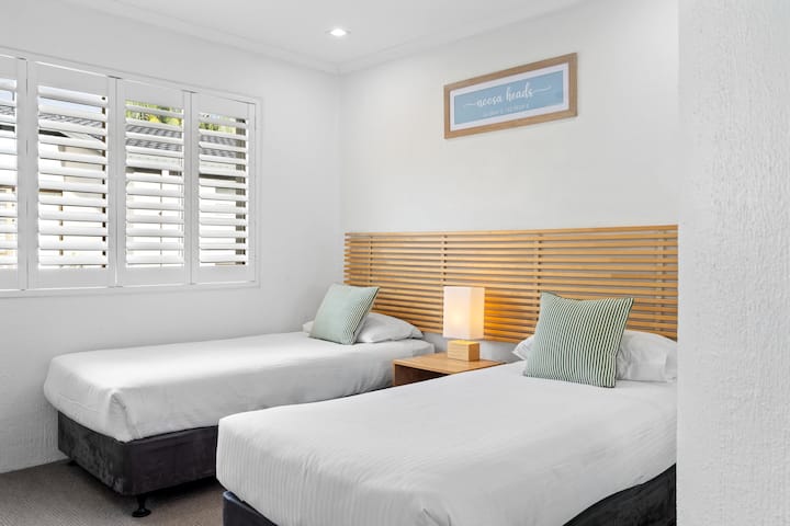 The second bedroom offers flexible bedding with two single beds that can be arranged together if preferred.