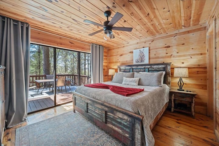 Comfy King Master Bedroom with private bathroom, closet, dresser, Smart TV, luggage holder, tower fan, and sliding glass door for access to porch.