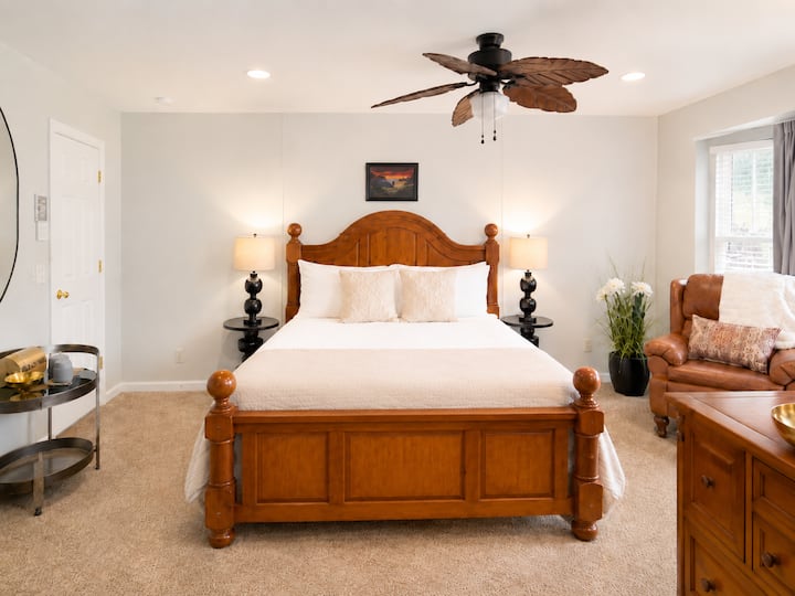 This comfortable bedroom offers a solid and luxurious wood bed, soft carpeting, and warm light throughout the day. Step outside to breathe in fresh mountain air, then return to rest—or unwind later with a soak in the outdoor hot tub.
