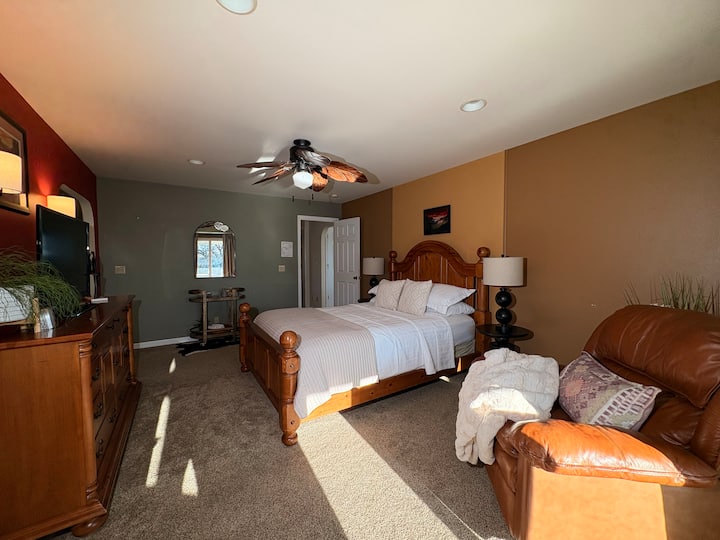 This comfortable bedroom offers a solid wood bed, soft carpeting, and warm light throughout the day. Step outside to breathe in fresh mountain air, then return to rest—or unwind later with a soak in the outdoor hot tub.


