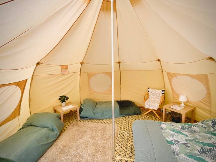 Dentro de la tienda de campaña, una cama doble y 2 camas individuales, para una familia de 4