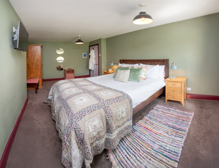 ️ King-Size Bedroom
Relax in a king-size bed with 400-thread-count bedding and extra pillows. Enjoy Smart TV, Wi-Fi, USB lamps, dressing table, wardrobe, and village green views — the perfect calm retreat. ✨