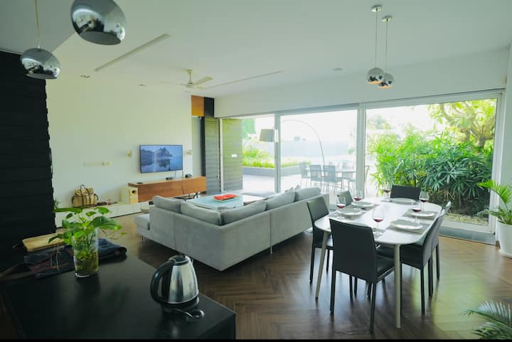 Living area inside Sofa, Dinning and kitchen with slide doors outdoor view