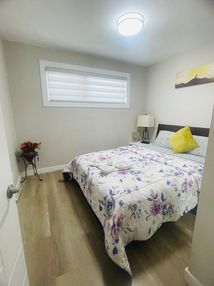 Una habitación luminosa y serena con sábanas con estampados botánicos de diseño, persianas zebra ajustables y toallas artísticas de estilo boutique.»