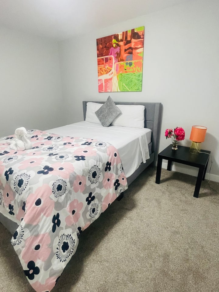 «Una habitación luminosa y artística con una cama queen con colchón de fibras, sábanas de diseño con estampado floral y una cálida bienvenida de estilo boutique».