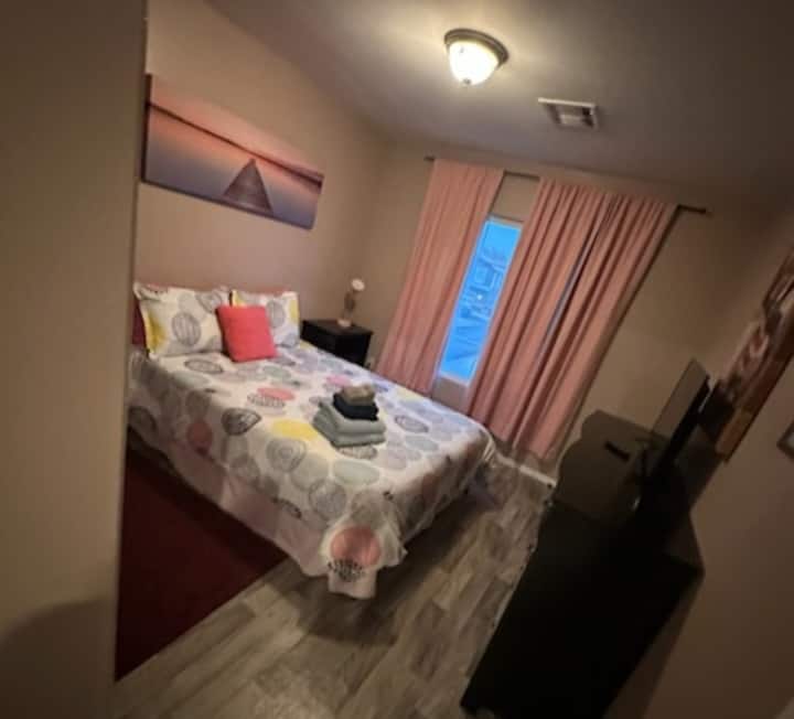 Cama queen en la habitación rosa