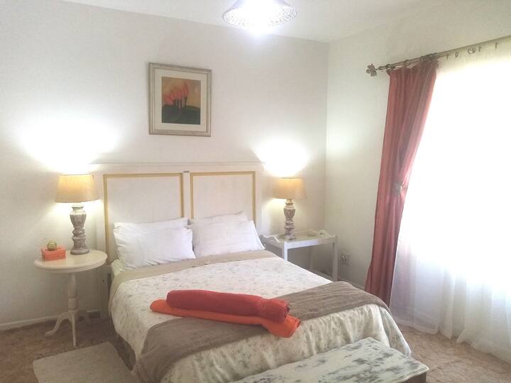 阳光明媚的卧室，配备一张标准双人床