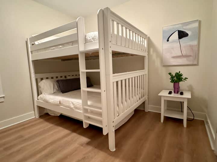 标准双人床双层床，配有双脚轮。  房间里还有一台电视。