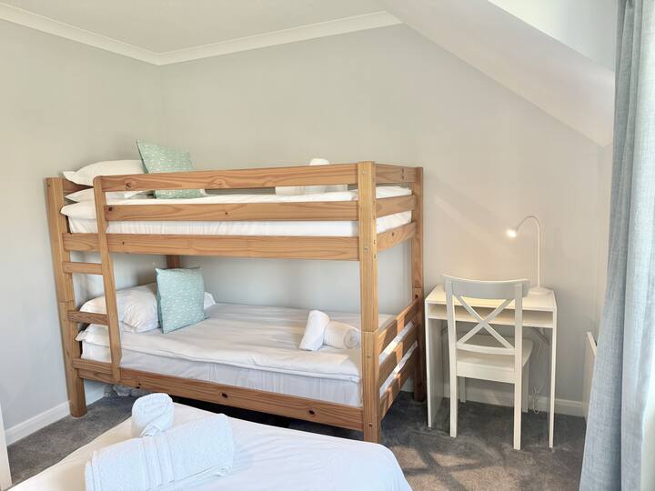 Втората спална соба е светла и светла. Удобни кревети и прекрасни меки нови теписи. Има мала работна станица, единечен кревет во целосна големина со основа за диван, кревет на спрат и ковчег со фиоки во целосна големина